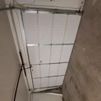 After - Insulated Garage Door Replacement with Modern Almond Raised Panel Design