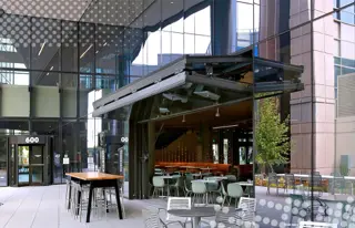 Glass bi-fold door open onto outdoor patio seating